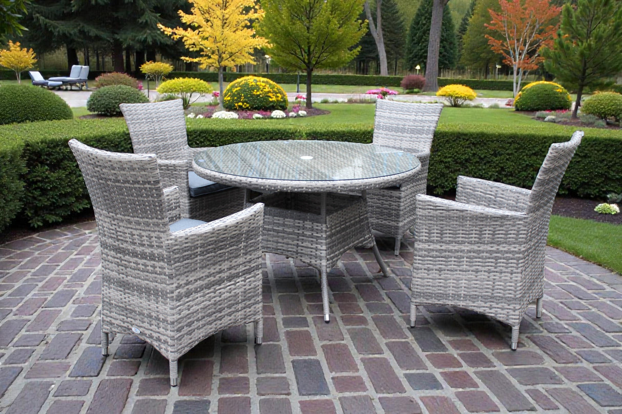 Madrid 4-seater garden dining set featuring grey rattan chairs with cushions and a central glass-topped table on a patio at furniture store ni