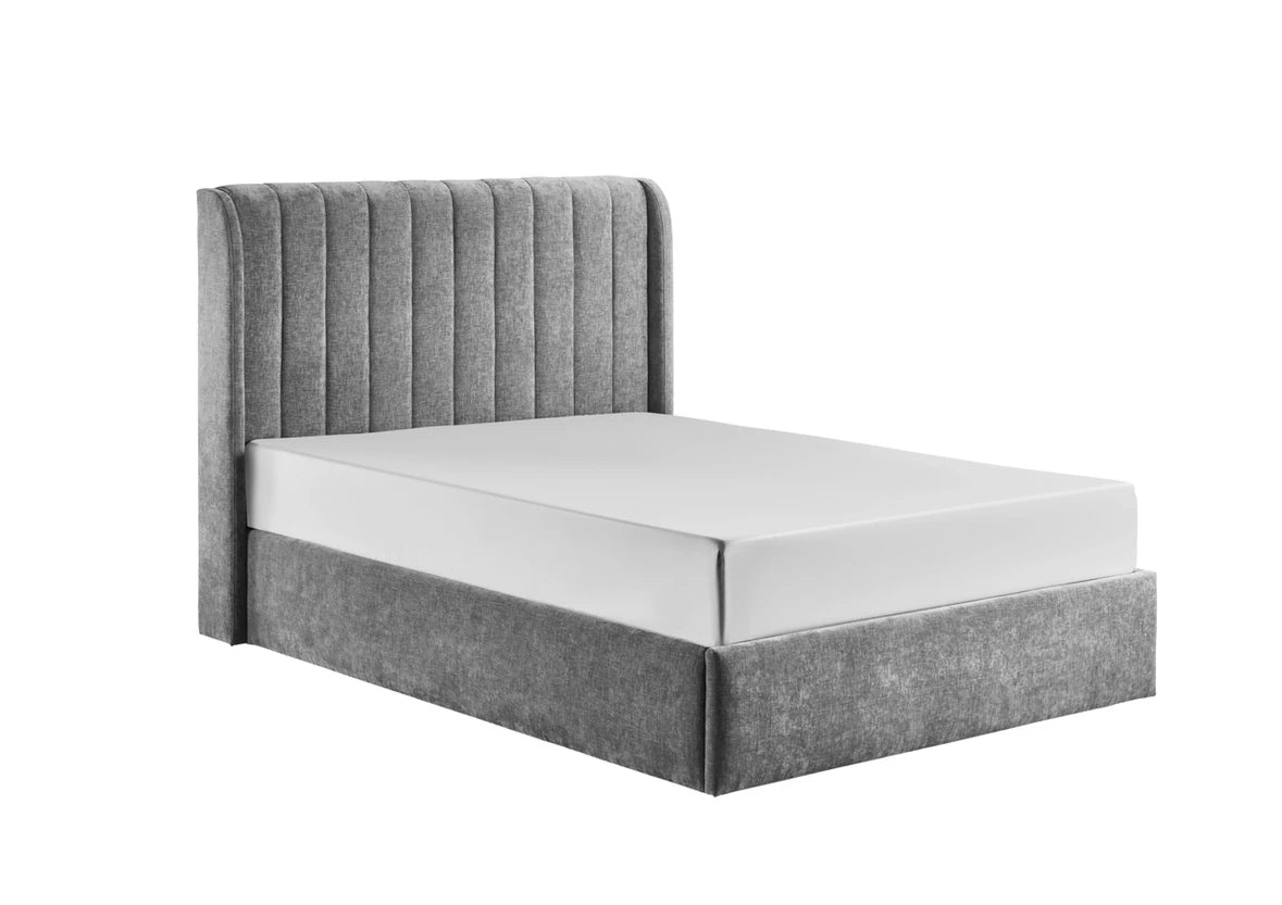 Frida storage bedframe in grey plush fabric, showcasing an elegant wingback headboard with vertical lines and a gas-lift base.