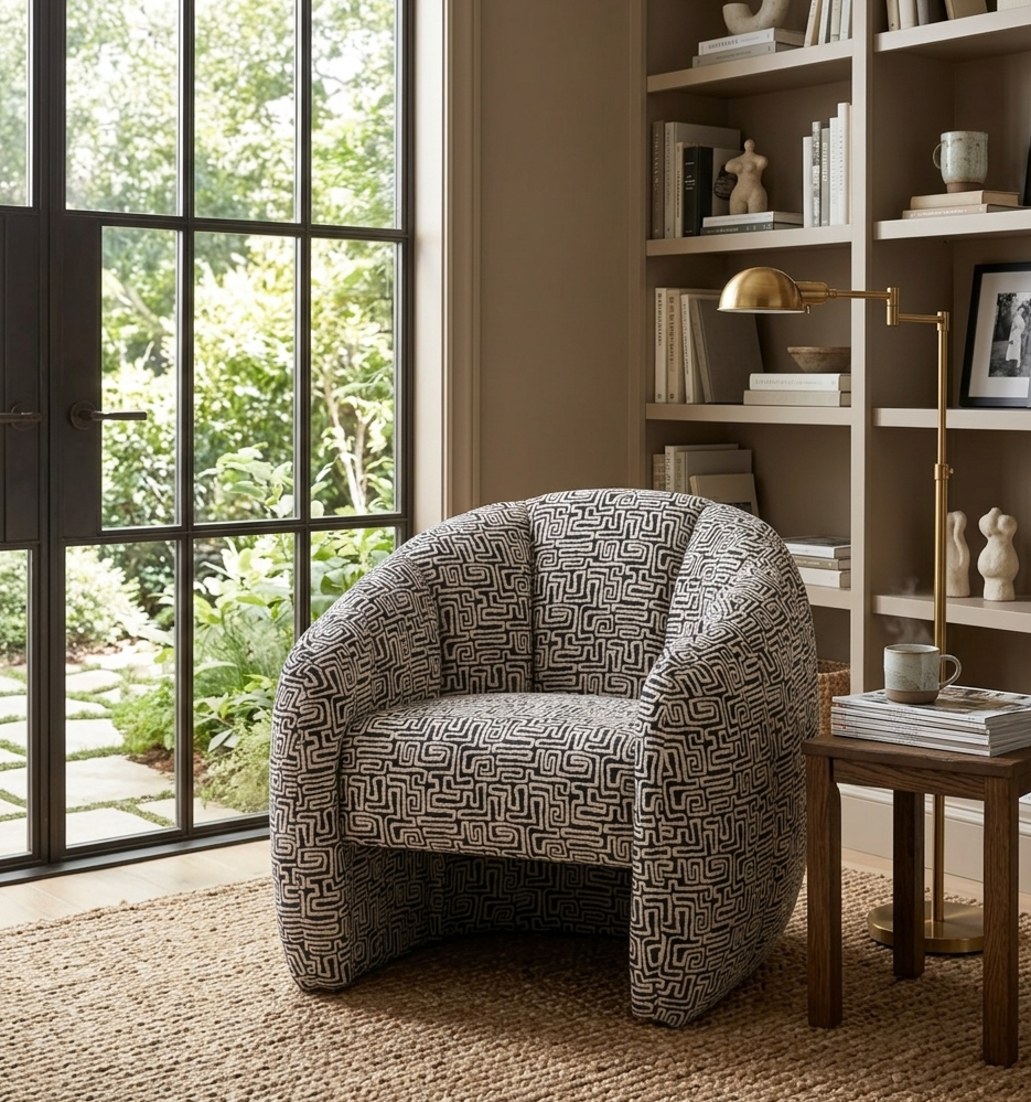 Atella contemporary tub chair in a striking black and white patterned fabric, highlighting its rounded silhouette and tailored vertical stitching at the furniture store ni.