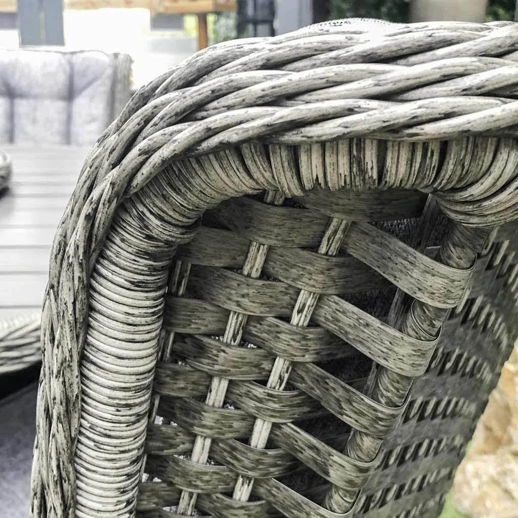 Close-up of a woven outdoor chair back in a weathered gray wicker or rattan material, showing the detailed texture and interlaced pattern.