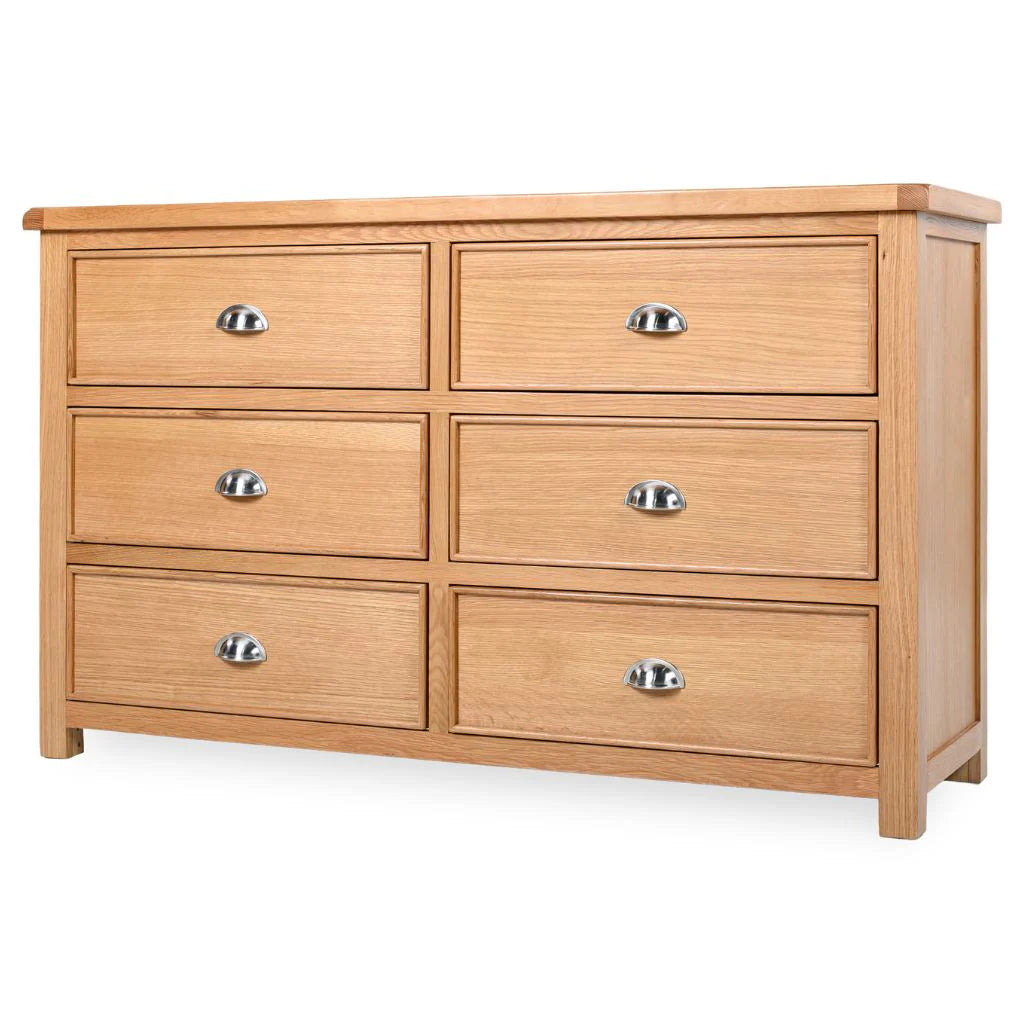 Newbury 6-drawer wide chest in light oak with distinctive drawer beading and polished silver cup handles at the furniture store ni