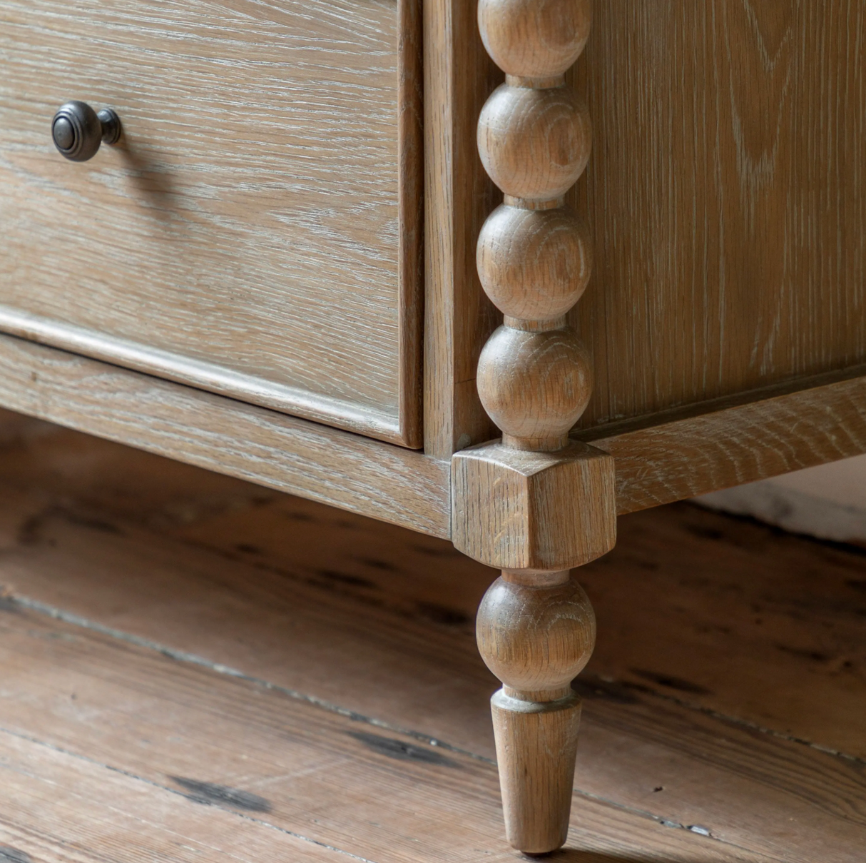 Artisan 3-drawer medium chest showcasing its exquisite hand-crafted bobbin turned frame details, premium oak wood grain, and a subtle lime wash finish at the furniture store ni