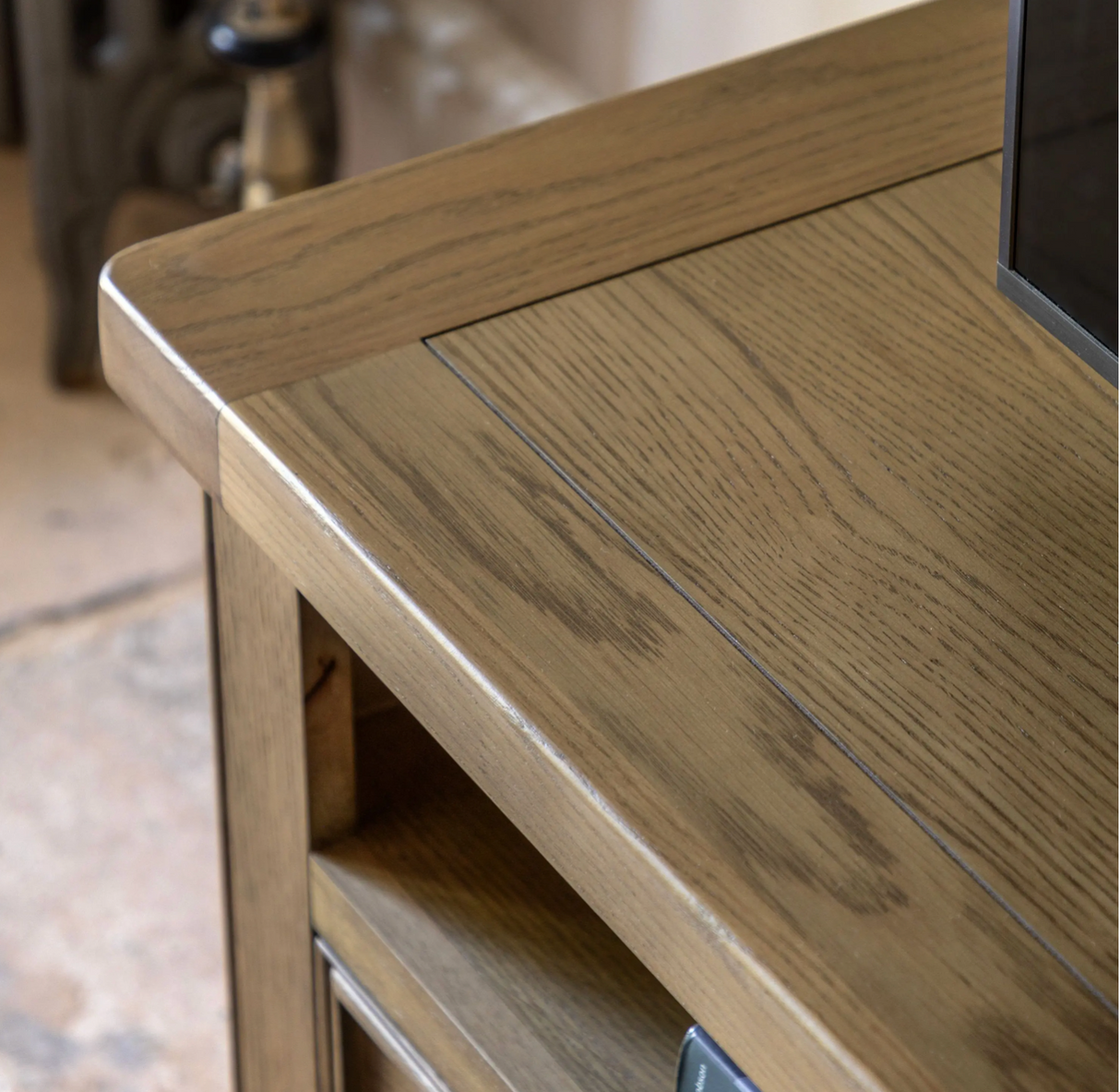 Hardwick large oak media unit showcasing its warm natural wood grain finish, robust solid construction, open device console, and two drawers with chic metal handles furniture store ni