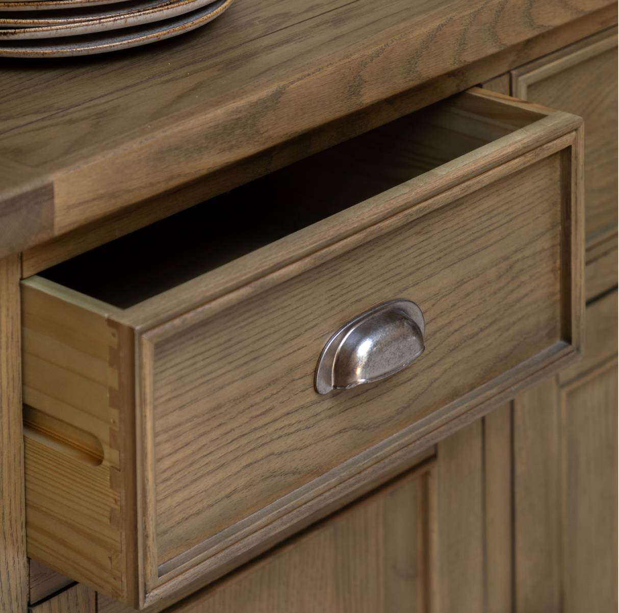 Hardwick large 3-door 3-drawer oak sideboard showcasing its expansive horizontal profile, warm natural wood grain finish, and classic metal handles at the furniture store ni