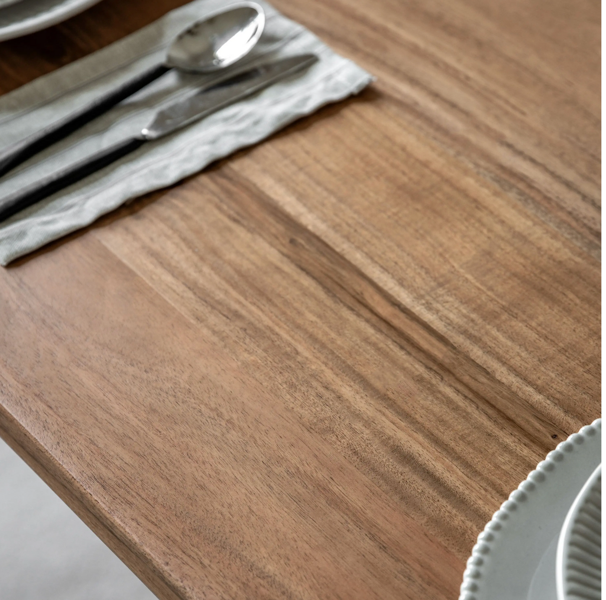 Wooden table with silverware on a white cloth at the furniture store ni