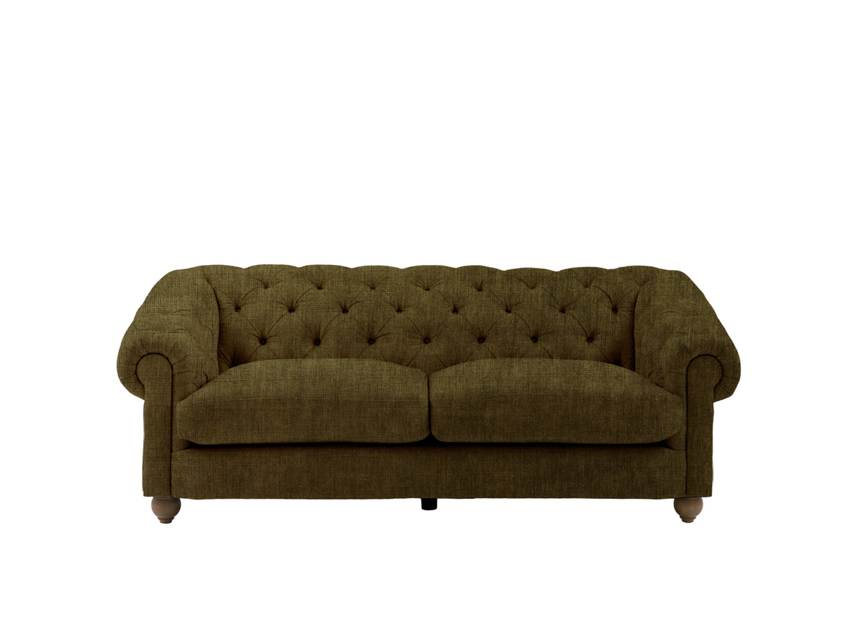 Modern 3-seater Chesterfield sofa showcasing its deep-buttoned back, elegant scrolled arms, and gracefully contoured silhouette sitting on solid ash legs Celine olive at the furniture store ni