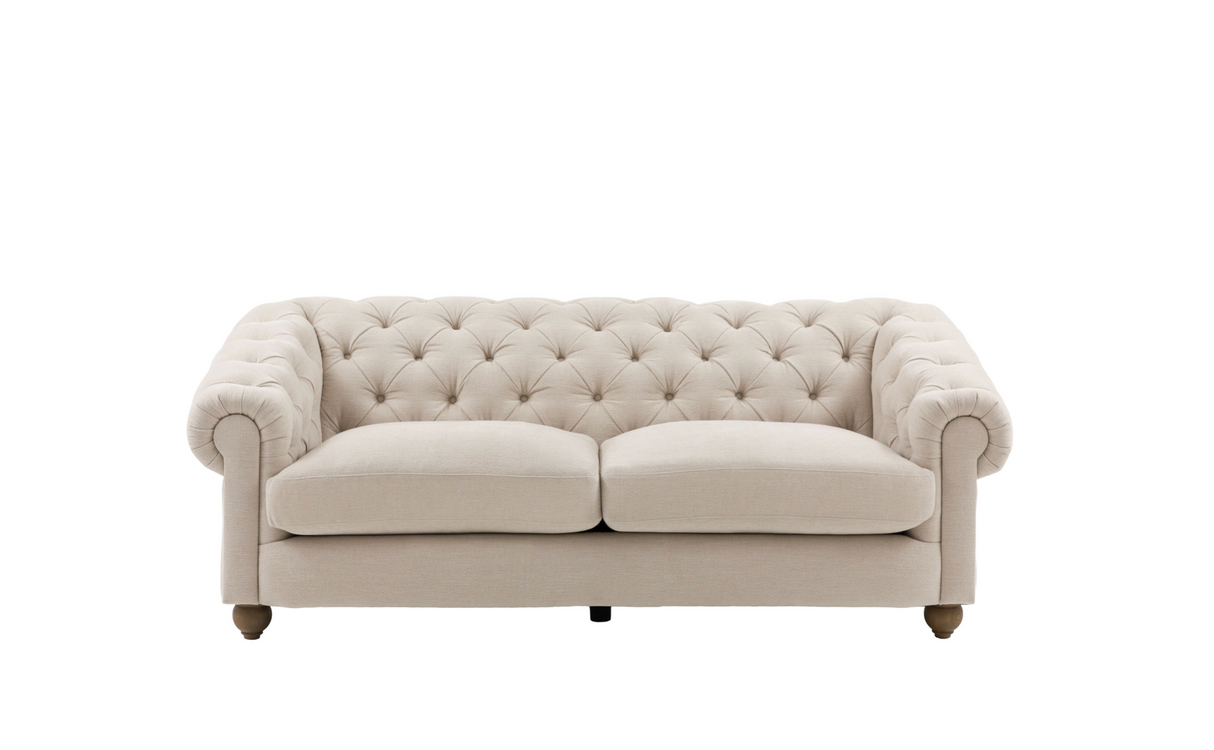 Modern 3-seater Chesterfield sofa showcasing its deep-buttoned back, elegant scrolled arms, and gracefully contoured silhouette sitting on solid ash legs.