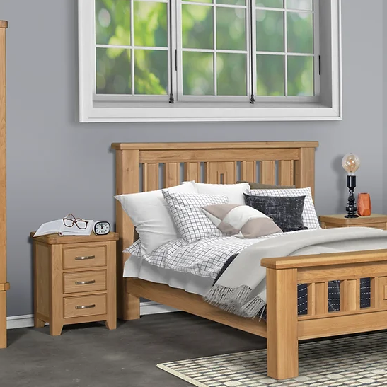Wooden bed with bedding and nightstands in a room with a window.