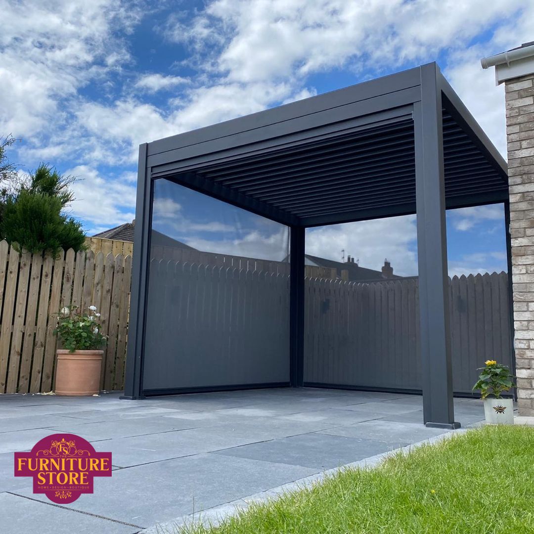 A sleek, pull-down privacy screen partially extended on a luxury pergola, creating a sheltered and secluded outdoor dining area in a contemporary landscaped garden furniture store ni