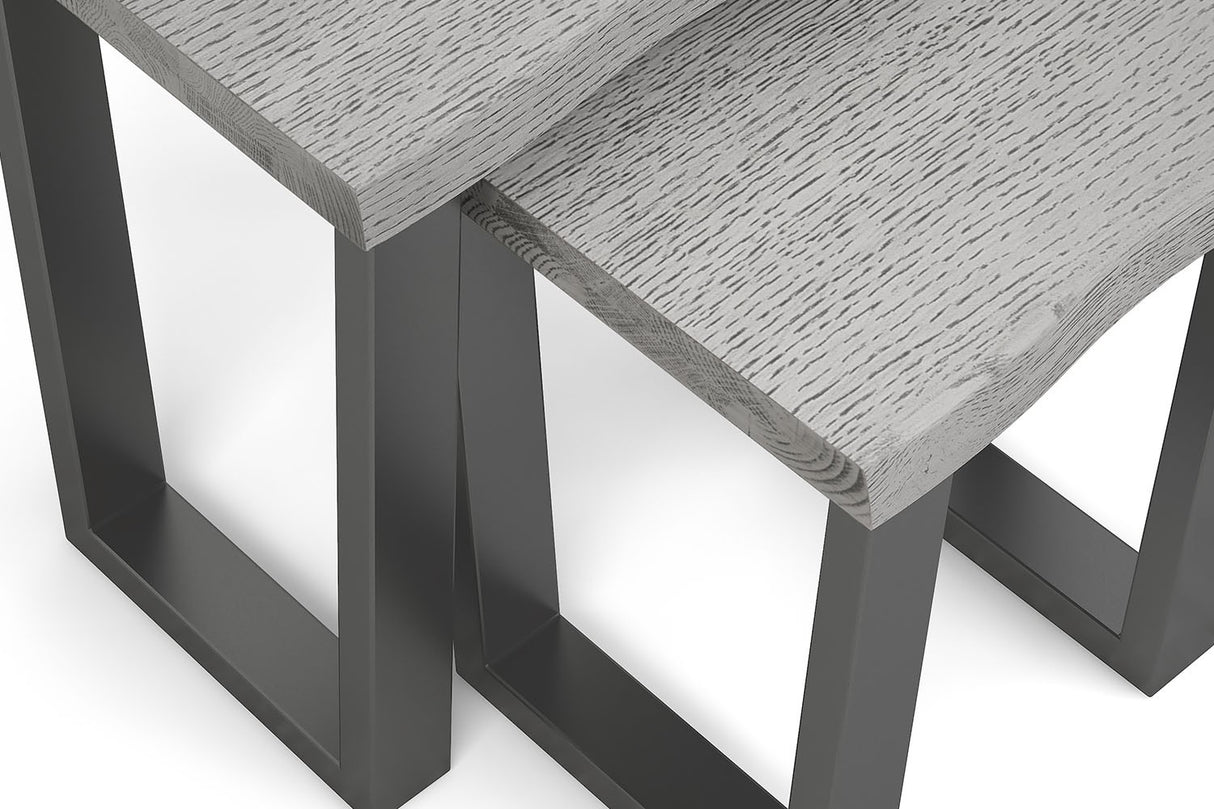 Close-up of a modern table with a light gray wood grain top and dark charcoal metal legs, shown on a white background.