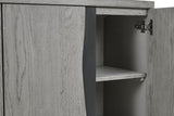Close-up of a light gray wood cabinet with one door open, showing the interior shelf and dark gray side panel.
