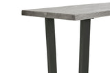 Close-up of a rectangular table showing a gray wood grain tabletop and dark charcoal metal legs on a white background.