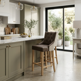 Jenna bar stool featuring rich Nutmeg PU leather seating, soft natural chenille upholstery detailing, and sturdy wooden legs at the furniture store ni