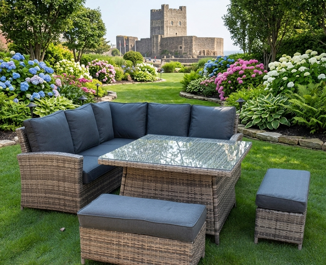 Maldives rattan garden corner sofa set with glass-top table, cushions, and additional stools set on a patio at the furniture store ni