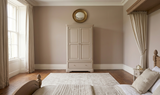 Mabel elegant 2-door double wardrobe painted in a soft taupe finish, featuring a robust oak structure, gorgeous curved details, and sleek silver handles at the furniture store ni