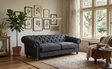 Modern 3-seater Chesterfield sofa showcasing its deep-buttoned back, in Celine battleship, elegant scrolled arms, and gracefully contoured silhouette sitting on solid ash legs Celine olive at the furniture store ni 