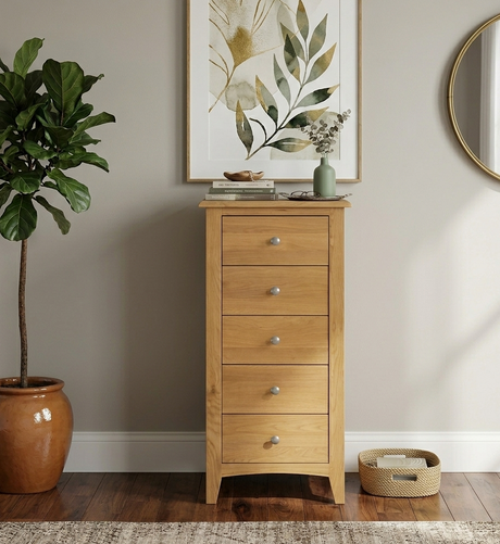 Kilkenny 5-drawer narrow solid oak chest, showcasing its vertical space-saving profile, curved top, and sleek chrome handles in a modern bedroom corner at furniture store ni