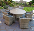 Florence 6-seater garden dining set with wicker chairs and a circular Polywood table, set up on a beautiful patio AT FURNITURE STORE NI