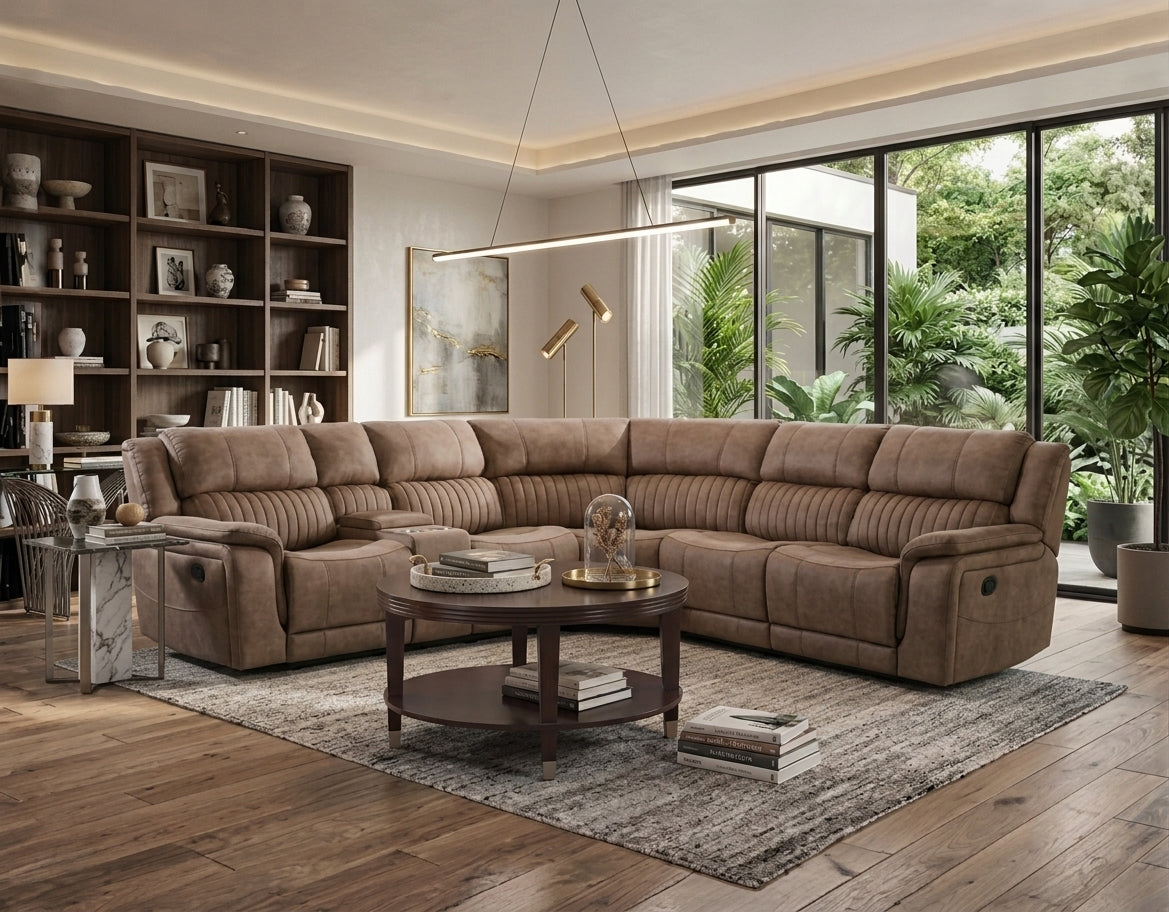 A large L-shaped sectional sofa upholstered in brown textured fabric, shown in a modern living room setting with a round wooden coffee table, a gray area rug, and large windows overlooking a green garden.