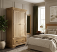 Oslo 2-door wardrobe in a light oak finish, featuring a thick tiered-top, robust plinth base, and contemporary hardware in a stylish bedroom setting furniture store ni