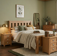 Newbury Wooden bedroom set with bed, nightstands, and dresser in a room with green walls at furniture store ni