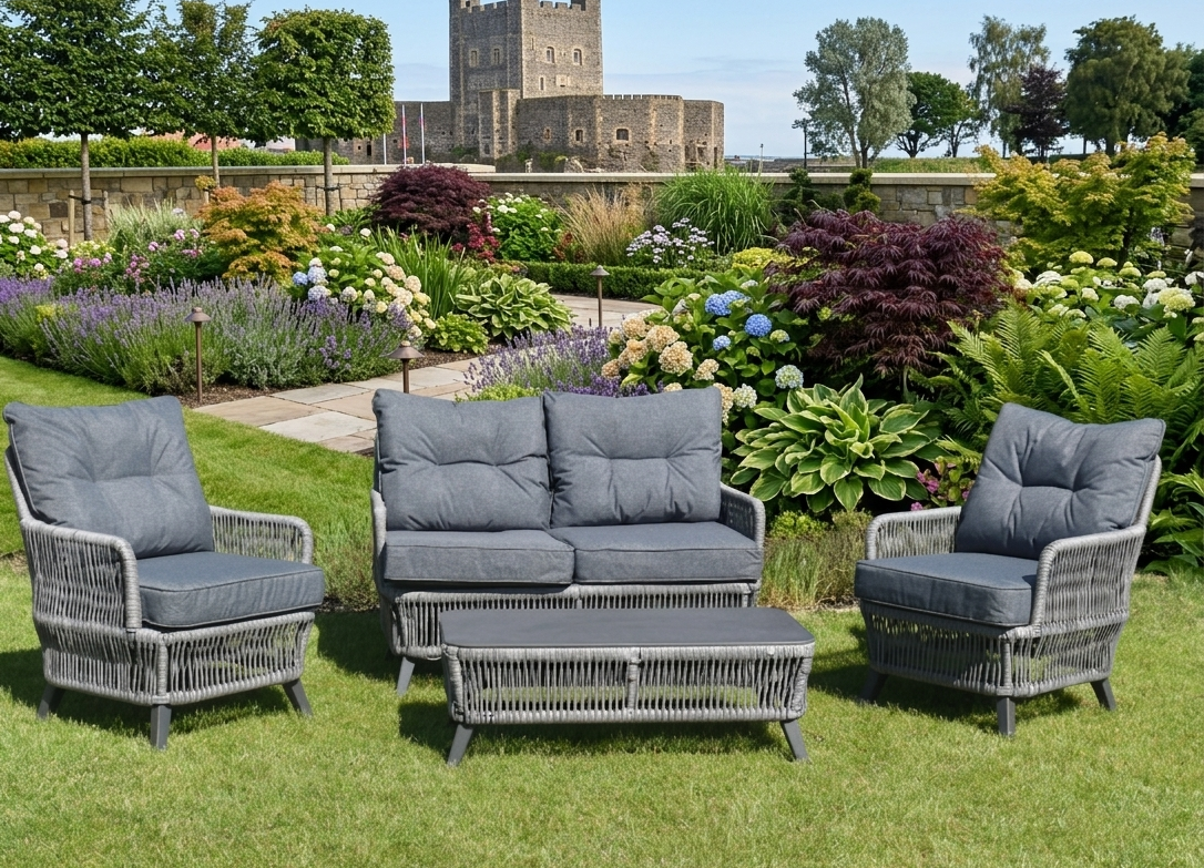 Rivera 4-piece garden furniture set including two rattan armchairs, a two-seater sofa, and a coffee table on a patio at the furniture store ni