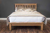 Manhattan solid oak bed frame with a natural wax finish, showcasing the rich wood grain and sturdy hand-crafted structure furniture store ni
