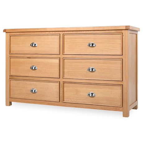 Newbury 6-drawer wide chest in light oak with distinctive drawer beading and polished silver cup handles at the furniture store ni