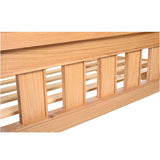 close up Newbury light oak bedframe in a bright, modern bedroom, highlighting the natural oak finish and clean lines.