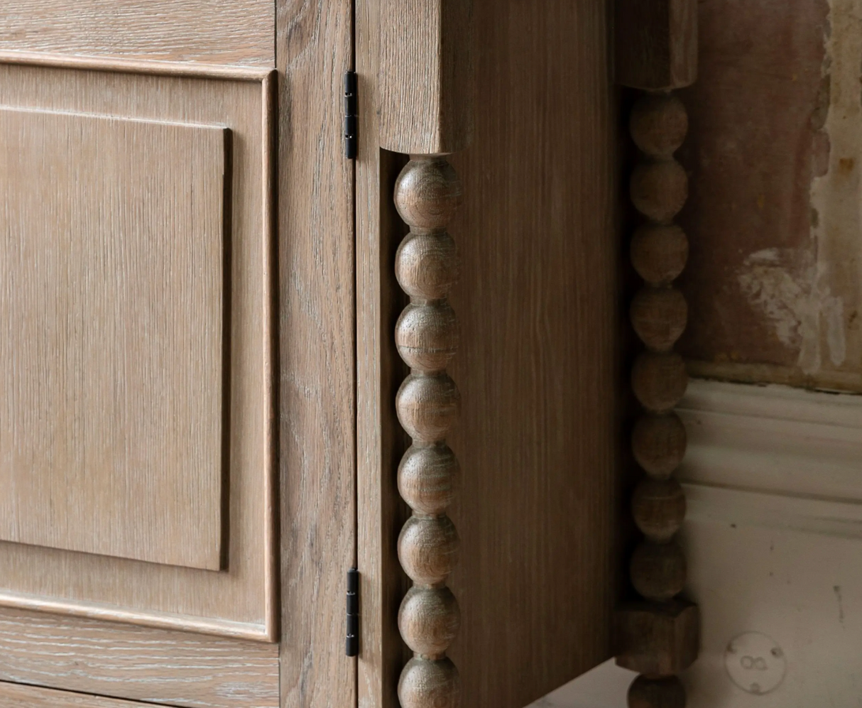 Wooden cabinet with decorative ball handles on a neutral background