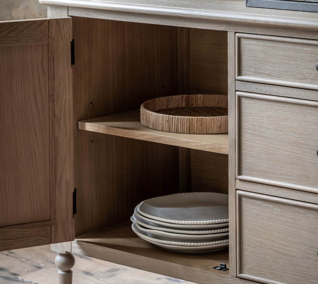 Wooden cabinet with open door revealing stacked plates inside