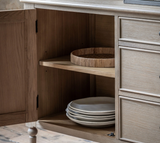 Wooden cabinet with open door revealing stacked plates inside