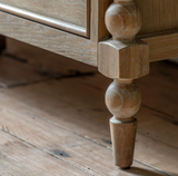 Close-up of a wooden furniture leg on a rustic wooden floor at the furniture store ni