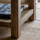 Hardwick square oak side table showcasing its warm natural oak wood grain finish, robust solid construction, and practical lower storage shelf at the furniture store ni