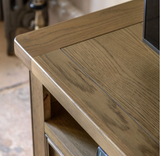 Hardwick large oak media unit showcasing its warm natural wood grain finish, robust solid construction, open device console, and two drawers with chic metal handles furniture store ni