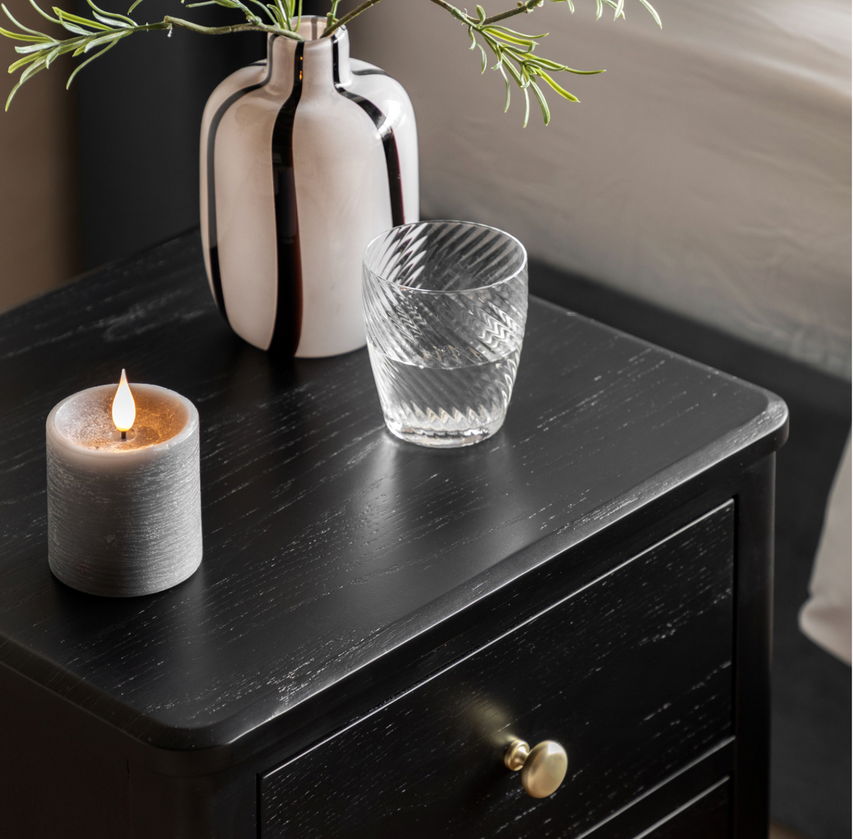 Candle, glass, and vase on a acton bedside locker sat the furniture store ni
