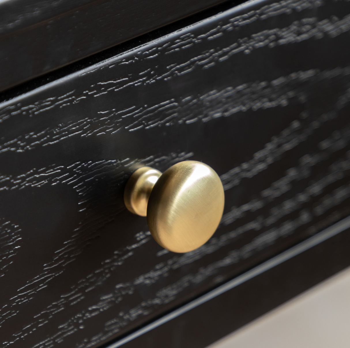 Black drawer with a gold knob on a neutral background at the furniture store ni