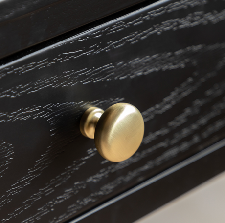 Black drawer with a gold knob on a neutral background at the furniture store ni
