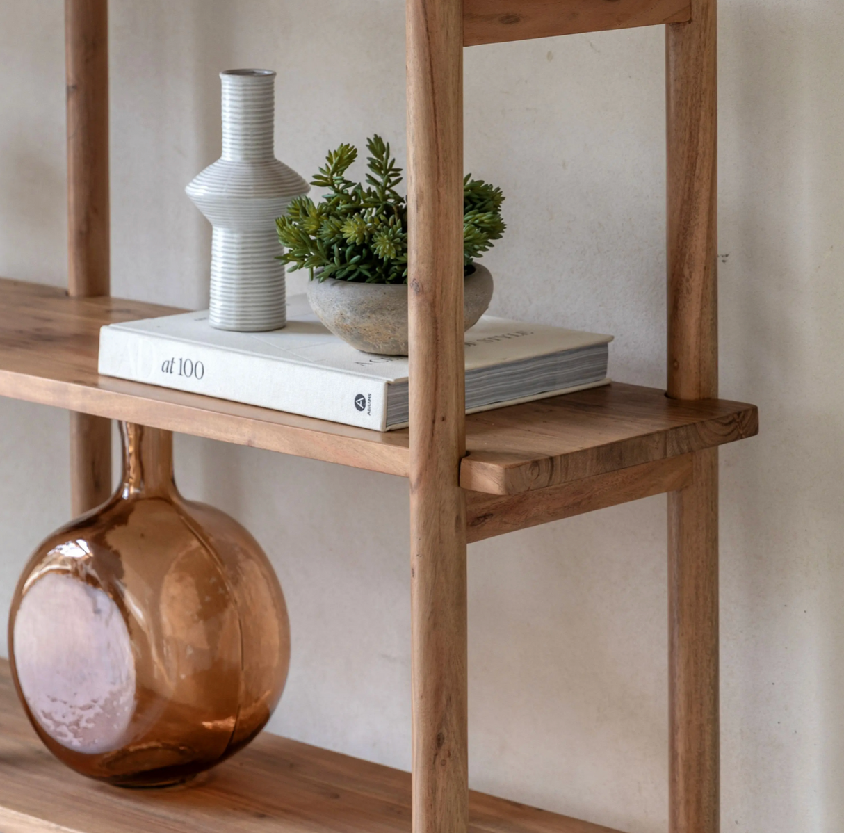 Cannes wide 4-tier open display unit made from warm acacia wood, showcasing its retro rounded uprights and slim, elegant shelves close up at the furniture store ni