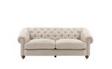 Modern 3-seater Chesterfield sofa showcasing its deep-buttoned back, elegant scrolled arms, and gracefully contoured silhouette sitting on solid ash legs.