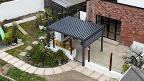 Hilton aluminium pergola featuring adjustable tilting louvres and a modern powder-coated finish, installed on a spacious garden patio at furniture store ni