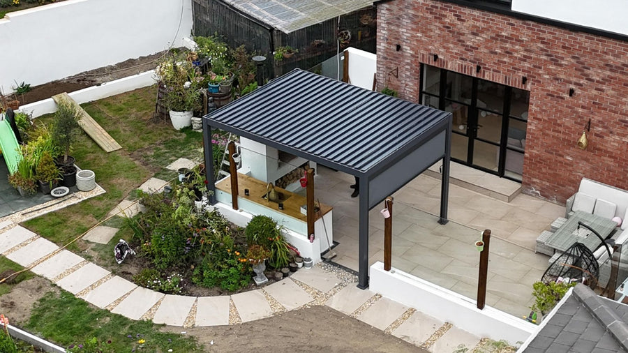 Hilton aluminium pergola featuring adjustable tilting louvres and a modern powder-coated finish, installed on a spacious garden patio at furniture store ni