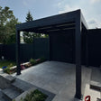 3m x 4m Neptune LED pergola featuring four retractable privacy screens and integrated lighting, set in a garden as a luxury outdoor dining area.
