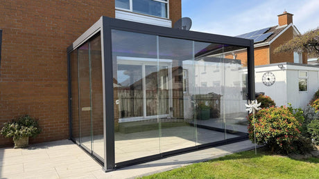 Nova Titan pergola featuring premium 10mm glass sliding doors, creating a stylish and weather-protected outdoor room furniture store ni